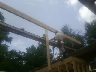 Carpenter setting a ridge beam over a new addition frame — Ice Dam Removal by Roofing Brothers in Blue Springs