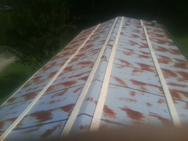 Rusted metal roof panels with new wood purlins before replacement — Storm Damage Roof Repair in Blue Springs by Roofing Brothers