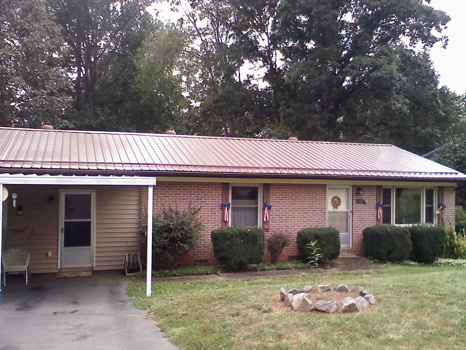 Bronze metal roof and carport on a brick ranch home — Roof Repair work by our crew in Blue Springs
